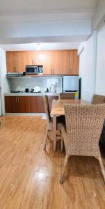 a kitchen with a wooden table and some chairs at SCANDIA SUITES AT SOUTH FORBES Homey & Cozy 2-Bedroom Condo in Silang