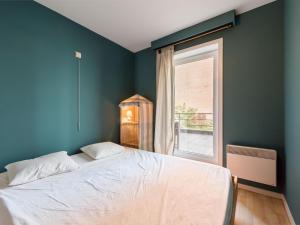 een slaapkamer met een groot bed en een raam bij Apartment in Koksijde near the Sea in Koksijde