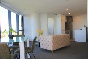a living room with a dining room table and a kitchen at Pinnacle Apartment in Auckland
