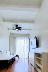 a living room with a couch and a ceiling fan at SCANDIA SUITES AT SOUTH FORBES Homey & Cozy 2-Bedroom Condo in Silang