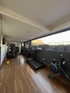 un gimnasio con varios equipos de ejercicio en una habitación en Apartamento moderno, en Colonia Mariano Roque Alonso