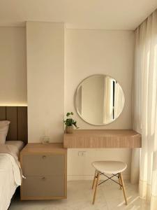 a bedroom with a mirror and a bed and a stool at Apartamento moderno in Colonia Mariano Roque Alonso