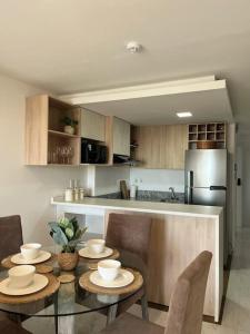 a kitchen with a table and some chairs and a counter at Apartamento moderno in Colonia Mariano Roque Alonso