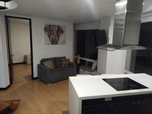 uma cozinha e uma sala de estar com um sofá em Espectacular Dúplex moderno em Bogotá