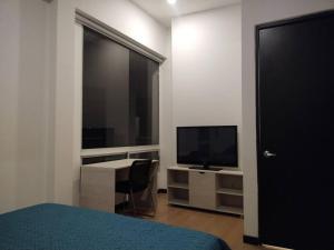 Dormitorio con cama, escritorio y TV en Espectacular Dúplex moderno en Bogotá