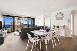 a living room with a table and chairs and a couch at Circle on Cavill 2, 3, 4 & 5 Bedroom SkyHomes & THE PENTHOUSE by Gold Coast Holidays in Gold Coast