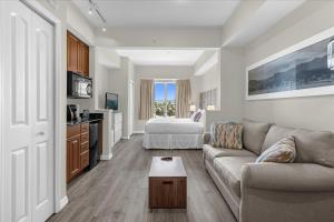 een woonkamer met een bank en een bed bij The Point, Lux Apartment 4 min from Universal in Orlando