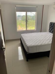 een bed in een kamer met een raam bij Casa en Villavicencio buena ubicación in Villavicencio