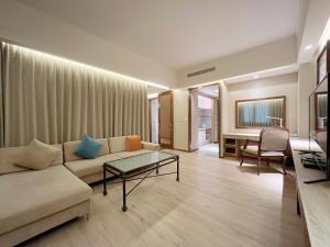 Jia Hsin Garden Hotel في تاى نان: غرفة معيشة مع أريكة وطاولة