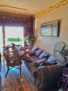 a living room with a large couch and a fan at Porto sokhna in Ain Sokhna