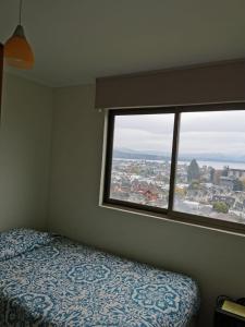 1 dormitorio con cama y ventana grande en Villarrica Mirador Apartment, en Villarrica