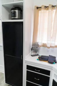 a kitchen with a black cabinet next to a window at Artful Retreat - King Bed, Work Desk, WIFI, Unique Murals, Perfect for Business Travelers, Downtown & Near Universal Studios in Burbank