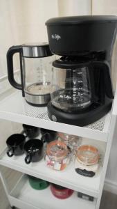 a coffee maker sitting on top of a shelf at Artful Retreat - King Bed, Work Desk, WIFI, Unique Murals, Perfect for Business Travelers, Downtown & Near Universal Studios in Burbank