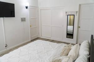 a white room with a bed and a mirror at Artful Retreat - King Bed, Work Desk, WIFI, Unique Murals, Perfect for Business Travelers, Downtown & Near Universal Studios in Burbank