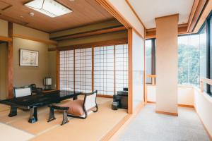 een kantoor met een bureau en stoelen in een kamer met ramen bij Hotel Gyokusen in Matsue