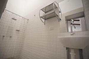 ein weißes Badezimmer mit einem Waschbecken und einem Spiegel in der Unterkunft Muyuterra in Moyobamba