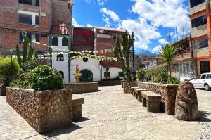 a group of benches in a courtyard with buildings at Makalu Lodge in Huaraz