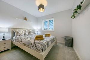 a white bedroom with a large bed with yellow pillows at Maidencraig Court House ✪ Grampian Lettings Ltd in Aberdeen