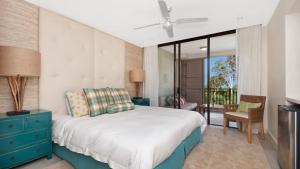 a bedroom with a bed with a blue dresser and a balcony at Penthouse - Palm Cove in Palm Cove