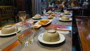 a table with plates of food and glasses of wine at Phong Nha Mountain House in Vực Trô