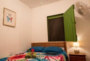 a bedroom with a bed with a green shutter at Finca D'Elía Lodge in Puerto Limón