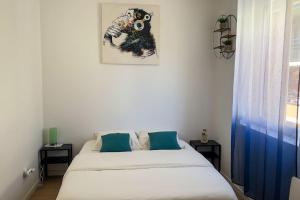 1 dormitorio con 1 cama y una foto en la pared en Maison de ville Rouen Darnétal en Darnétal