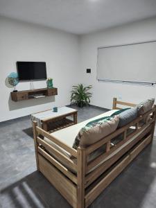 a large wooden bed in a room with a flat screen tv at Duplex Del Valle in San Fernando del Valle de Catamarca