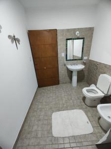 a bathroom with a toilet and a sink and a mirror at Duplex Del Valle in San Fernando del Valle de Catamarca
