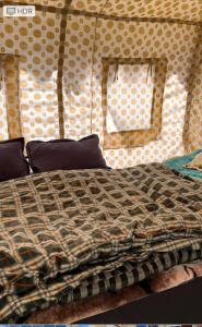 Bhrigu Camps في Jispa: سرير في خيمة مع لحاف عليه