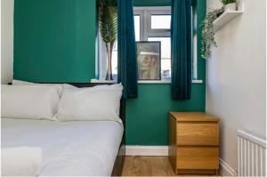 ein Schlafzimmer mit einem Bett und einer grünen Wand in der Unterkunft 3Bed house near Nottingham city centre in Nottingham