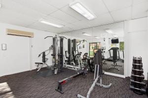 een fitnessruimte met diverse loopbanden en een spiegel bij Executive 2br Suite On Mounts Bay Road in Perth