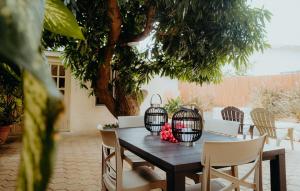 a wooden table with chairs and two bird cages on it at Homey Vacation in Willemstad