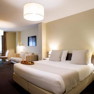 uma grande cama branca num quarto de hotel em Ikonik Plaza Mercado em Salamanca