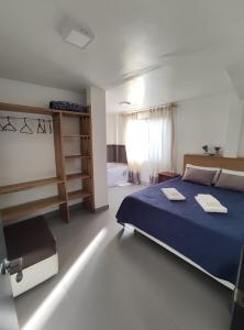 ein Schlafzimmer mit einem blauen Bett und einem Fenster in der Unterkunft Elegante apartamento con vistas al volcán Tungurahua in Baños