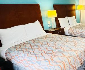 une chambre d'hôtel avec 2 lits et 2 lampes dans l'établissement Relax Inn Lawton, à Lawton