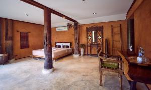 Bambuh Boutique Homestay في Ban Den: غرفة نوم فيها سرير ومكتب
