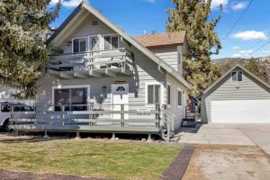 ein weißes Haus mit einer Veranda und einer Garage in der Unterkunft The Getaway Cabin in Big Bear City