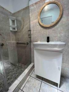 a bathroom with a shower and a sink and a mirror at Mi casa El Rincón in Juana Diaz +10 photos