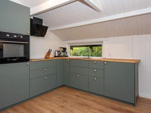 una cocina con armarios verdes y una ventana en Holiday home Egernsund X en Egernsund
