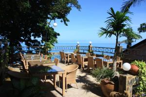 a patio with tables and chairs and the ocean at Top Resort in Ko Chang