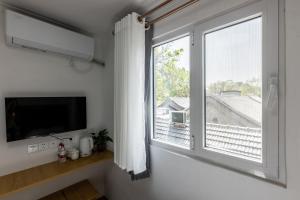 a living room with a large window and a tv at Happy Dragon Hotel National Art Museum Metro Forbidden City in Beijing