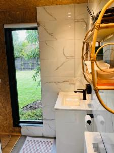uma casa de banho com um lavatório e uma janela em holiday tiny house near park em Vermont South
