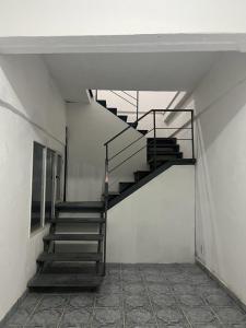 Una escalera de metal en una habitación con una pared blanca en Alojamiento ruta 3 en Trelew