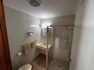y baño con ducha, aseo y lavamanos. en Balranald Colony Inn Motel en Balranald
