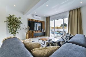 Una sala de estar con un sofá azul y un televisor. en Villa Jomani, en Bibinje