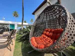 a hanging rattan swing in front of a house at SAL di Mare Hotel Boutique - Frente ao Mar com Piscina in Guarujá