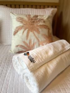 a towel sitting on top of a bed with a pillow at MAKAI Milagres in São Miguel dos Milagres
