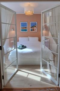 um quarto com uma cama branca e uma porta de vidro em Appartement Vieux Nice em Nice