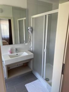 ein Bad mit einem Waschbecken und einer Dusche in der Unterkunft Pension Wob in Wolfsburg