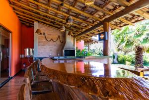 a bar with a large wooden table in a room at Rancho Recanto da Serra in Delfinópolis